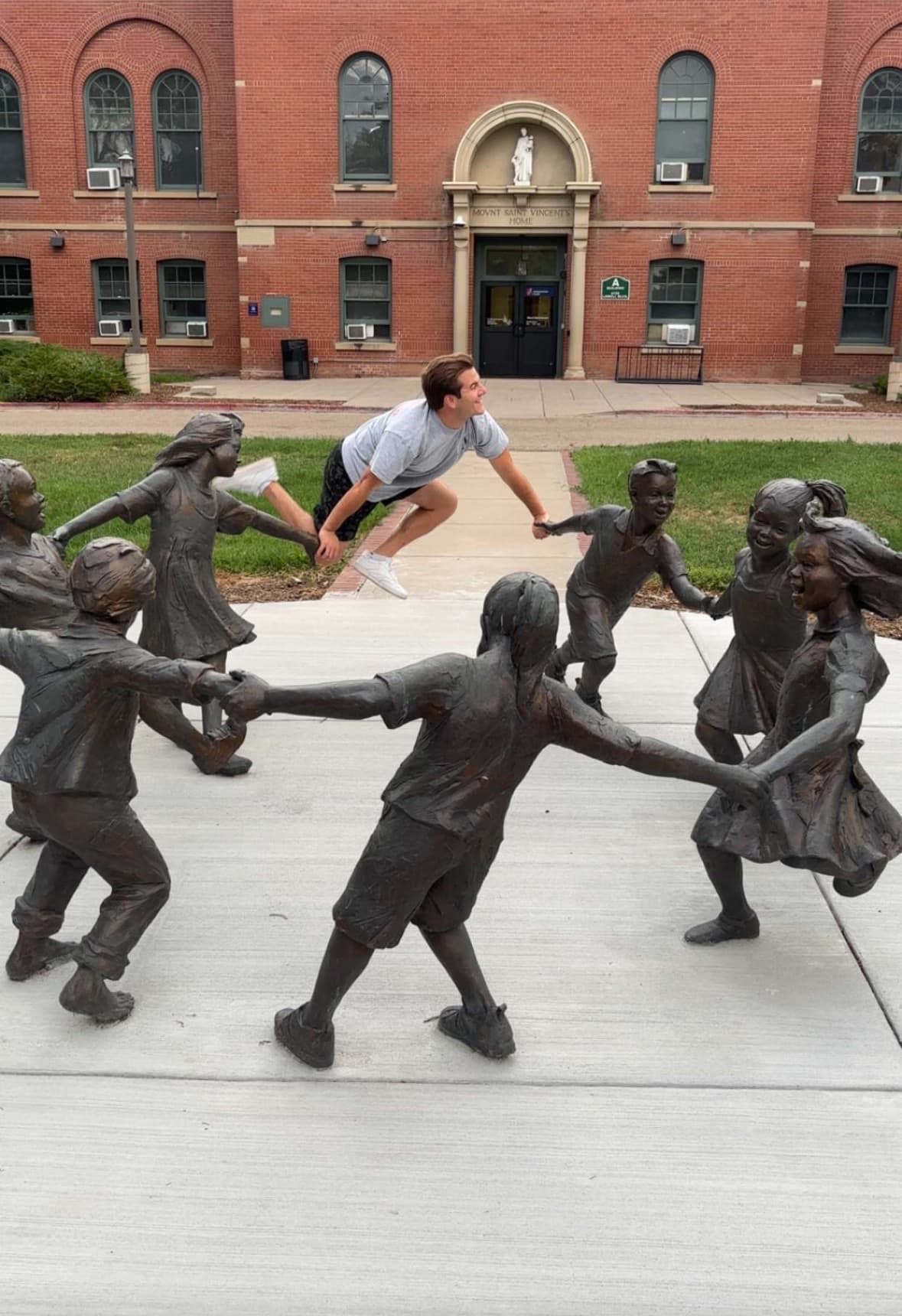 Blake leaping into a ring of bronze children statues